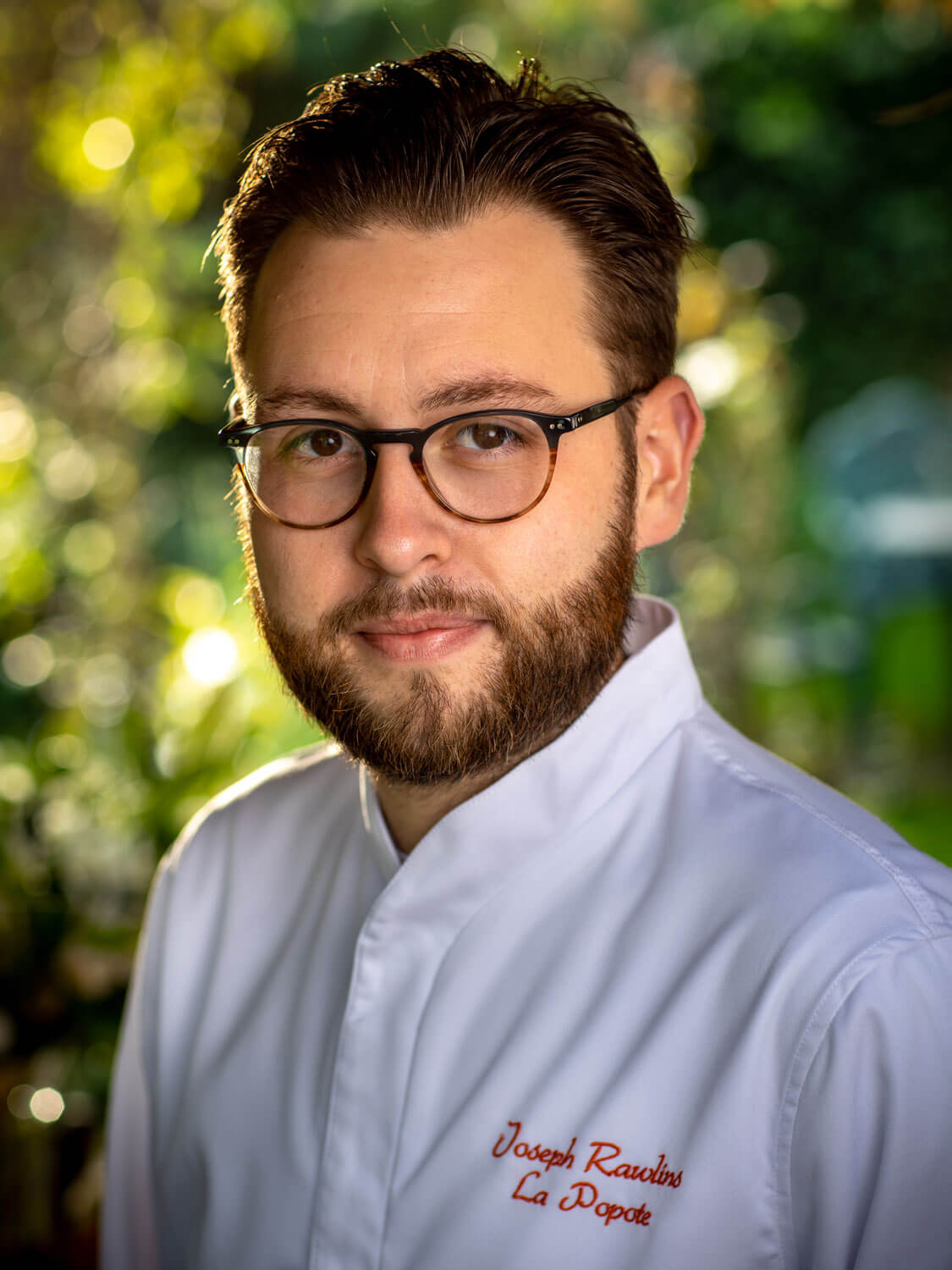 Chef Joseph Rawlins Smiling at the camera in his white jacket